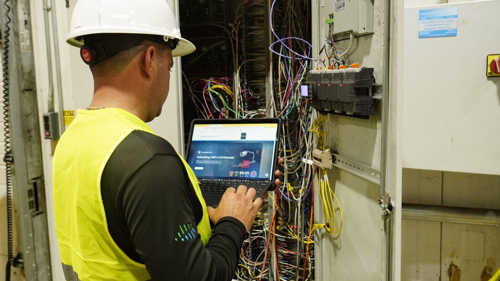 Dynamiq technician checking real-time monitoring data at a refrigeration control panel